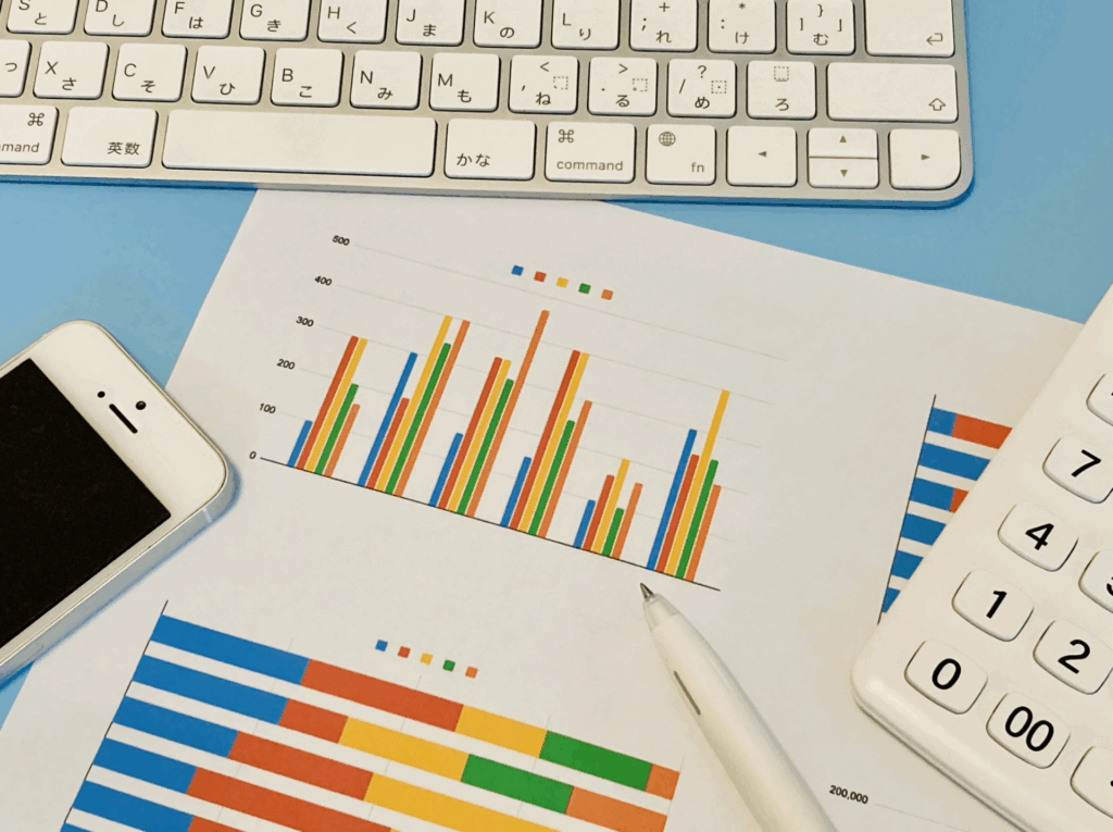 PCデスクの上のグラフとスマホ