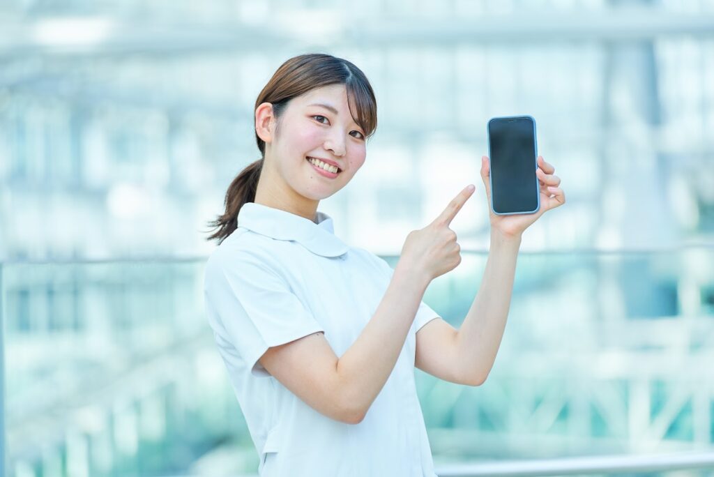 スマホを指差す女性看護師