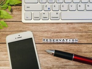 デスクの上にあるスマホと「RESERVATION」の文字
