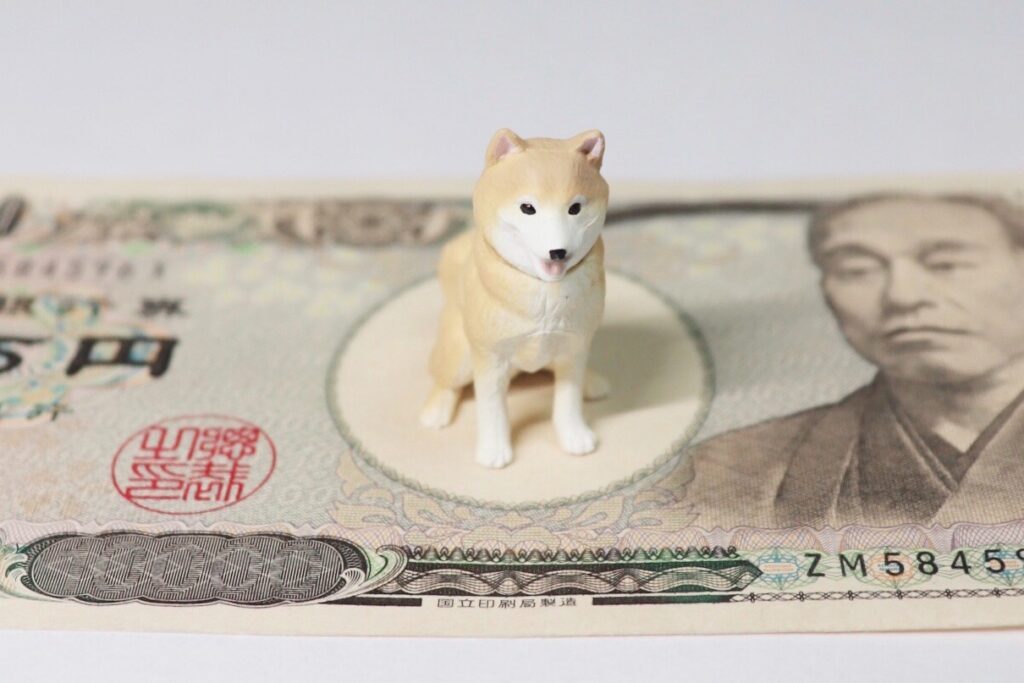 1万円札の上に乗る犬の置物