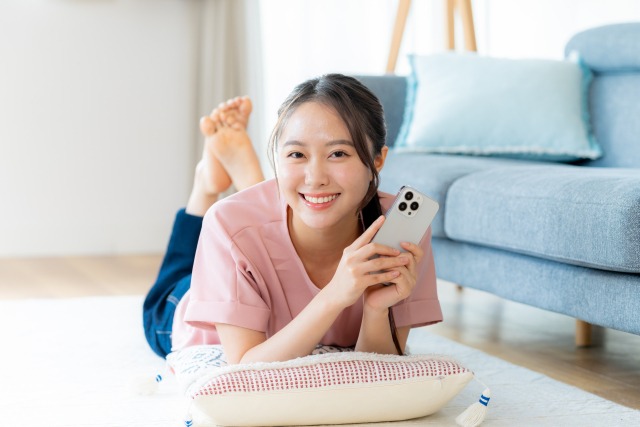 笑顔でスマホを触る女性