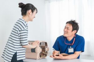診察をする獣医師と飼い主
