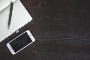 机に置かれたノートとスマホ