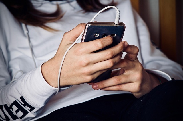 スマホで音を聞きながら触る女性