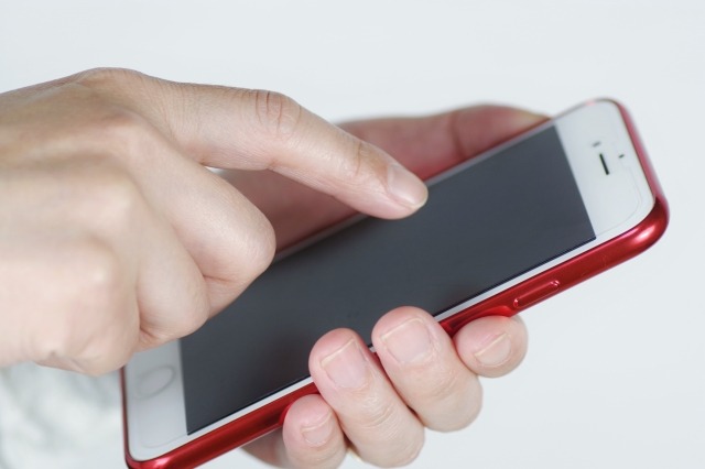 赤いスマホを触る様子